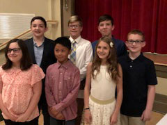 Group of 7 students nicely dressed, standing on risers.
