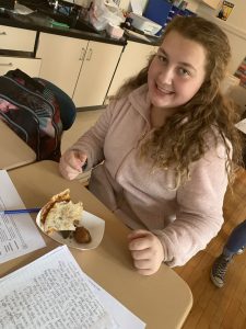 a student samples foods at their desks in a school classroom