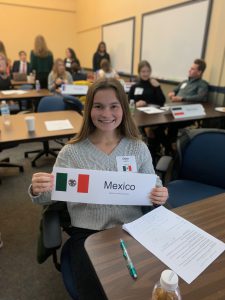 eight students hold signs representing foreign countries