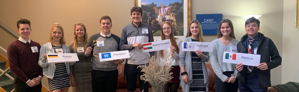 eight students hold signs representing foreign countries