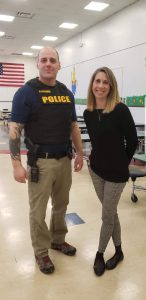 officer in uniform with a school principal in a school cafeteria