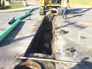 construction crews work on a water line outside of an elementary school