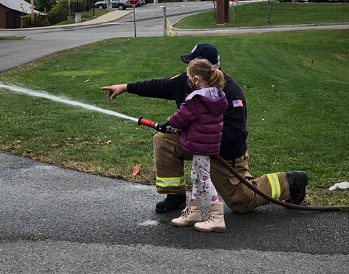 Student learning how to use a fire hose