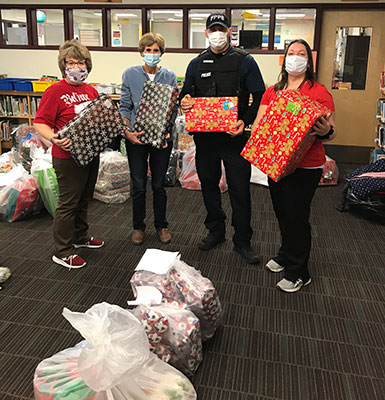 four people holding Gram Lorraine gifts in the library