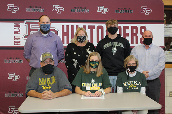 Sarah seated at table with coaches, brother and parents 