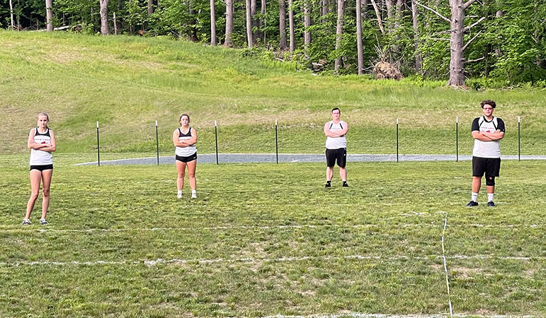 Four students standing on discus field