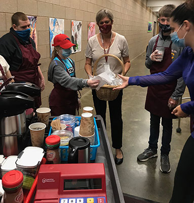 students serving staff from their coffee cart