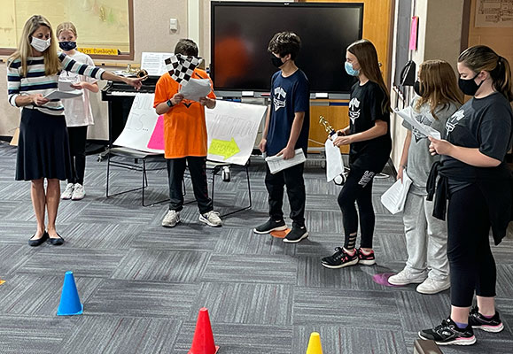Principal Crisman with students performing the play
