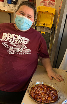 Student posing with food in classroom