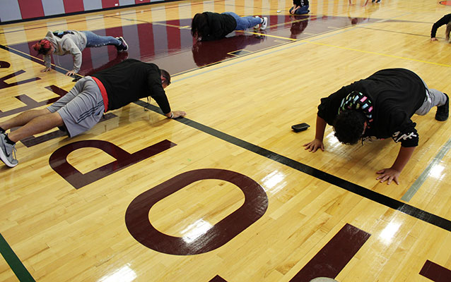 Casey Russom leading students doing push-ups in the gym