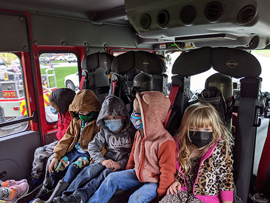 Pre-K students sitting inside a fire truck