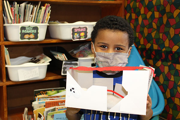 student holding their monster trap