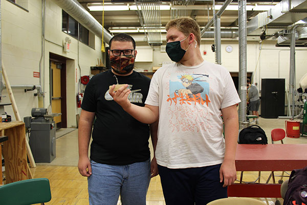 2 students holding zipper pull prototype