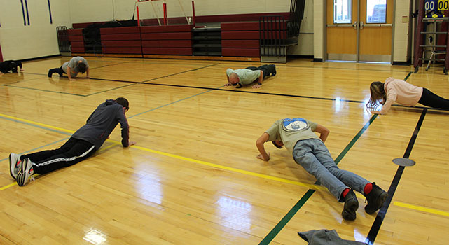 Commander Ellwood leads students in doing push ups