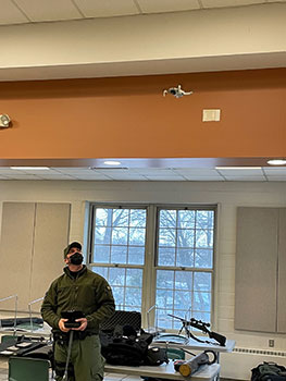 officer flying a drone in the classroom
