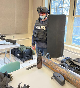 officer wearing protective gear and holding a shield