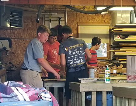 Ethan and friends work in grandfather's shop in 2019