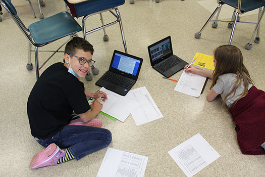 students sitting on floor, working on comics