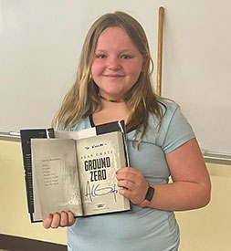 Kinley holding autographed book