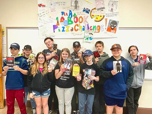 students holding books and smiling