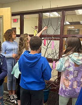 students hanging wishes on the wish tree