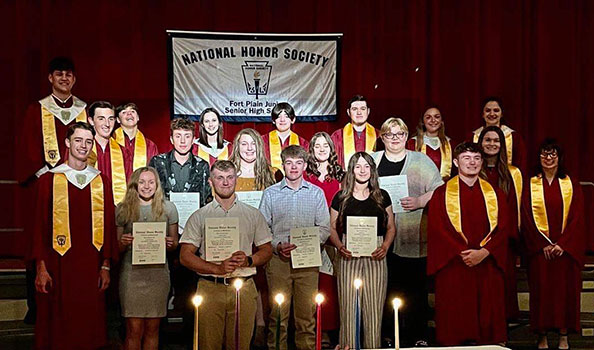 students holding certificates in front of NHS banner