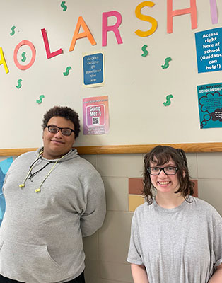 Talia and Braeden standing in front of their display