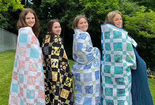 students with quilts wrapped around them
