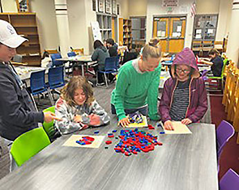 adult and students engaging in a math-related activity