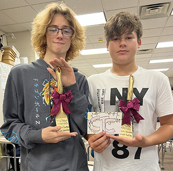 2 students holding award spatulas