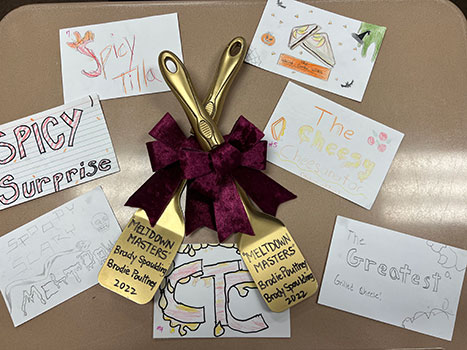 award spatulas and entry name illustrations on a table