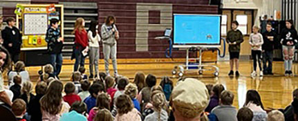 Adult and students at veterans assembly in the gym