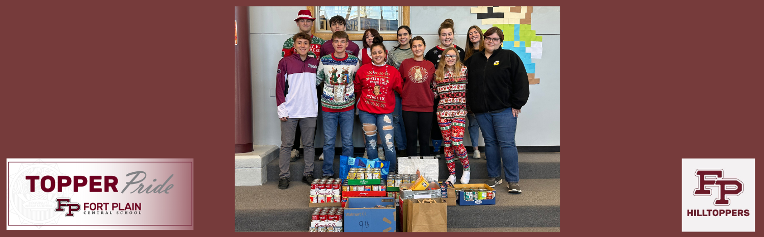Students standing in front of food drive donations