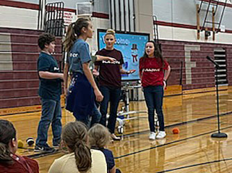 students and school counselor perform role play while other students look on