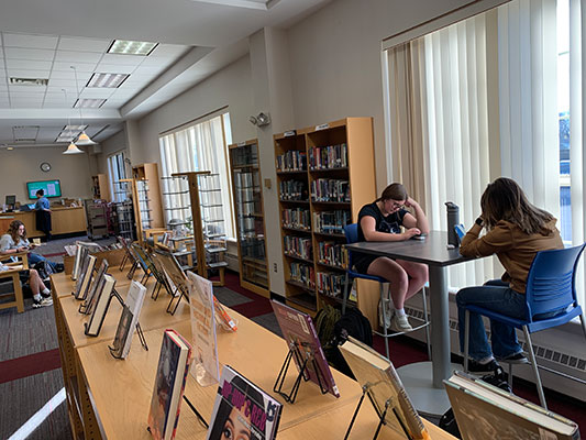 students sitting at high-top tables next to big windows