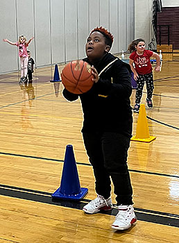 student holding basketball in gym