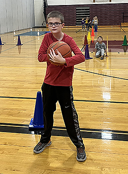 student holding basketball in gym