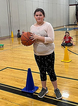 student holding basketball in gym