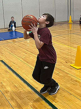 student holding basketball in gym