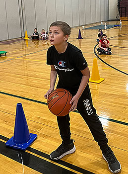 student holding basketball in gym