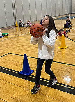 student holding basketball in gym