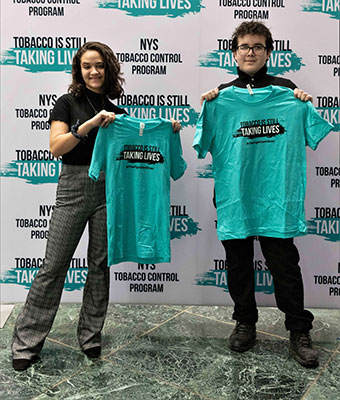 2 students holding t-shirts