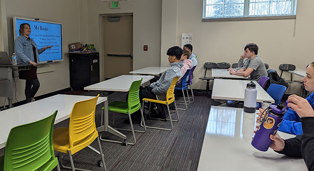 Allyson talking to students in a library classroom