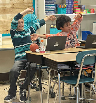 students with their hands raised in the air