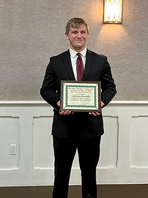 Anthoony holding his plaque