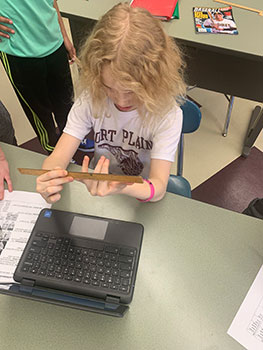 student measuring her hand with a ruler