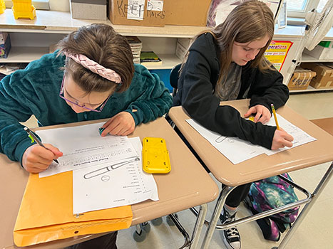 2 students working on paperwork at their desks