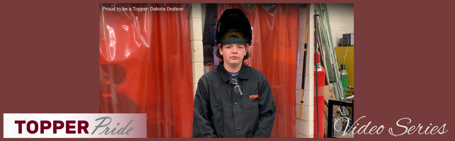 Dakota Dodson standing in front of a welding booth