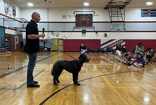 police officer talking to students with dog on leash