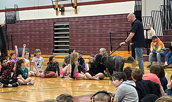 police officer talking to students with dog on leash near students